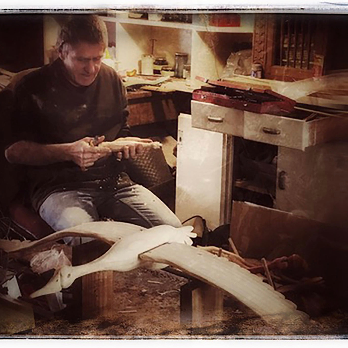 Wood Carver hand carving a wooden bird mobile in a workshop behind the scenes look