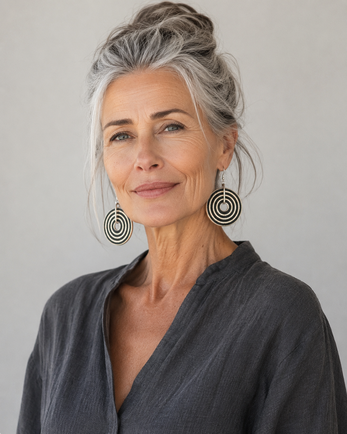 Woman wearing handcrafted black and white ostrich eggshell statement earrings with a contemporary circular design, artisan jewellery handmade in South Africa.