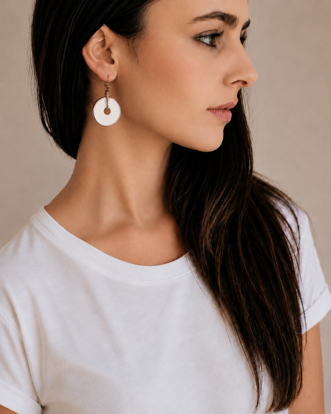 Woman wearing handcrafted natural ostrich eggshell disc earrings, lightweight contemporary artisan jewellery handmade in South Africa.