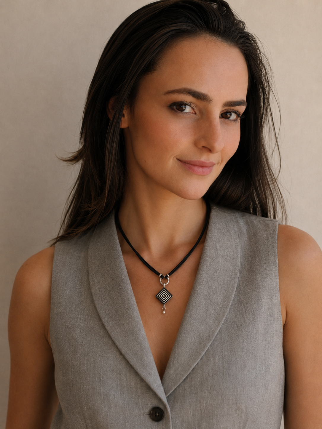 Woman wearing a handcrafted petite geometric ostrich eggshell necklace on a black suede cord, contemporary artisan jewellery handmade in South Africa.