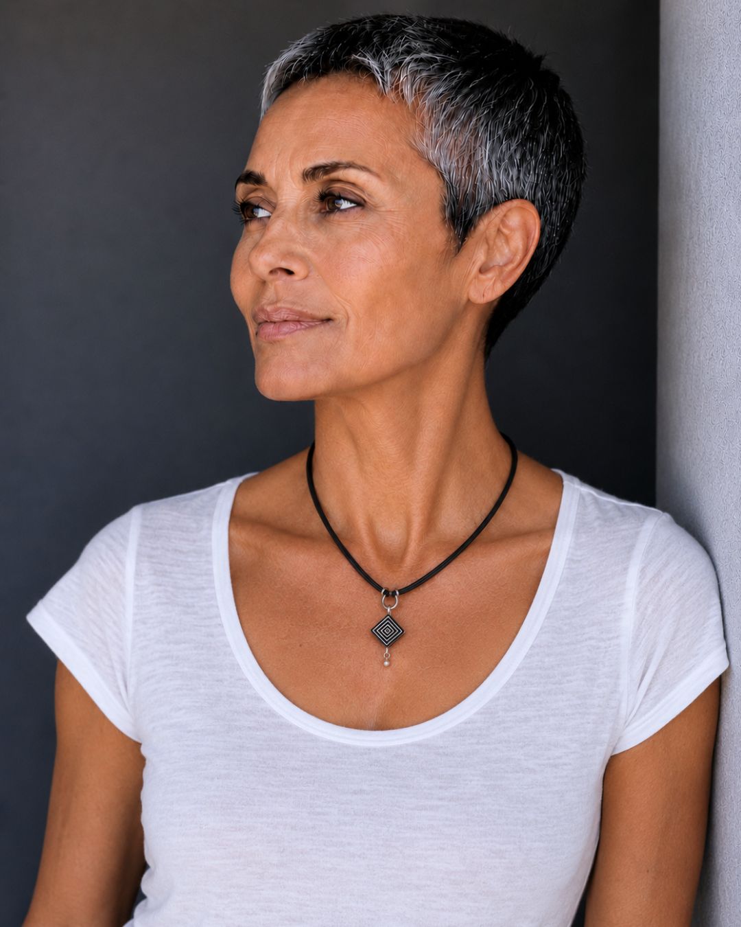 Model wearing a petite handcrafted ostrich eggshell geometric pendant necklace with a black suede cord and contemporary minimalist design.