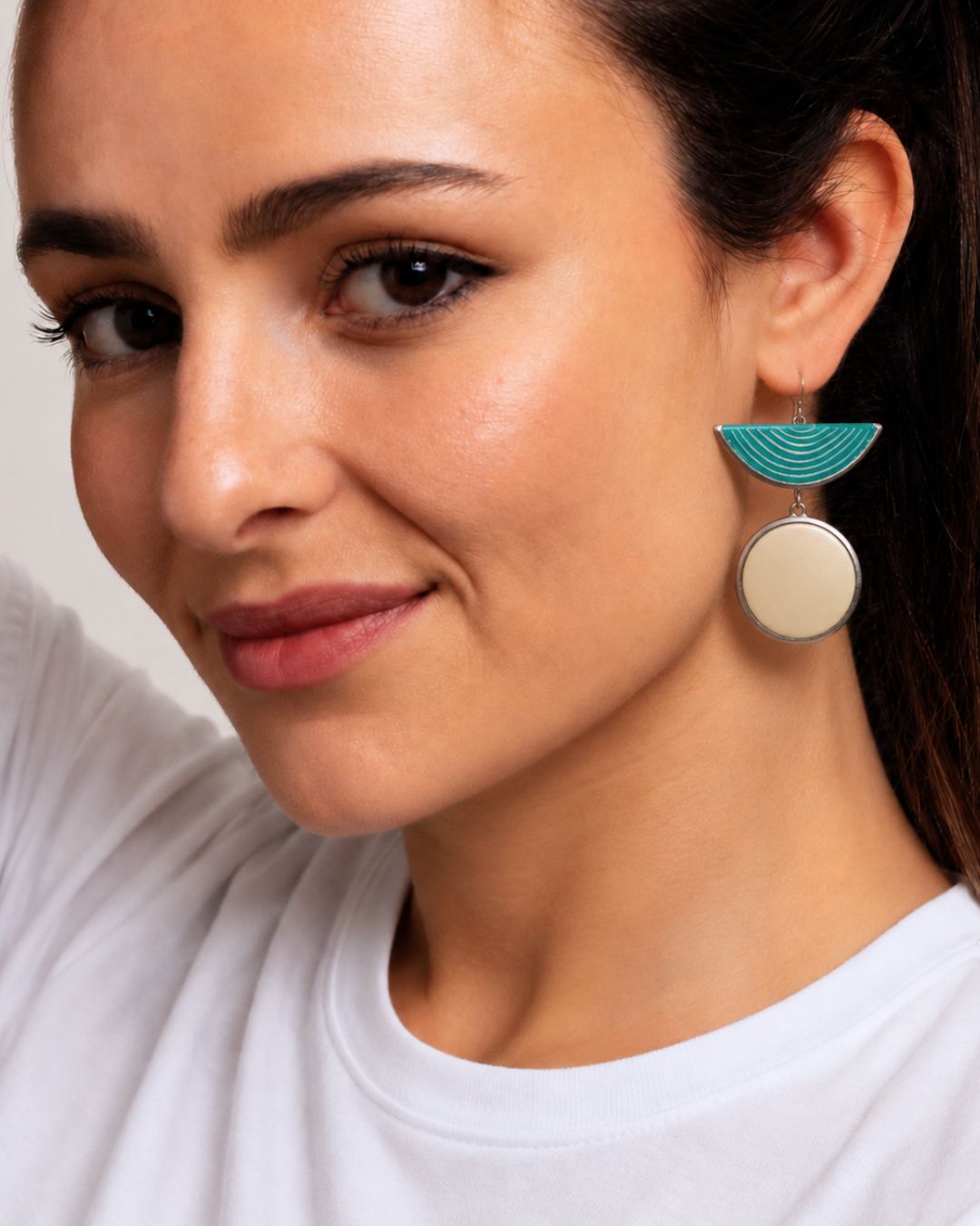 Woman wearing handcrafted turquoise half moon and natural ostrich eggshell statement earrings handmade in South Africa.
